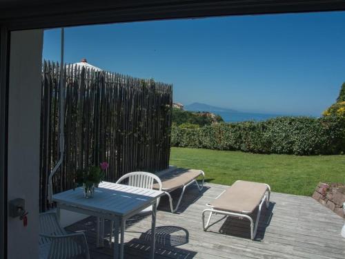 eine Terrasse mit einem Tisch, Stühlen und einem Zaun in der Unterkunft Maison Bista Eder in Bidart