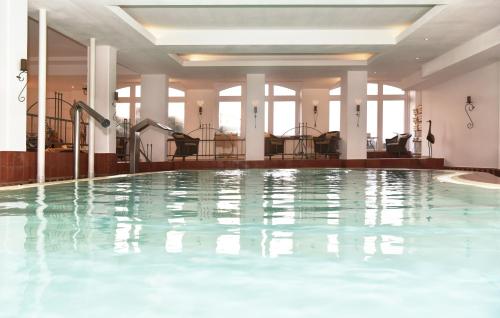 une grande piscine dans le hall de l'hôtel dans l'établissement Hotel Miramar, à Westerland