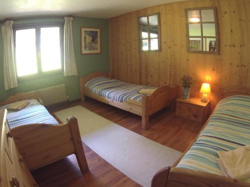 a bedroom with two beds in a room with wooden walls at B&B Chalet Les Frenes in Chamonix-Mont-Blanc