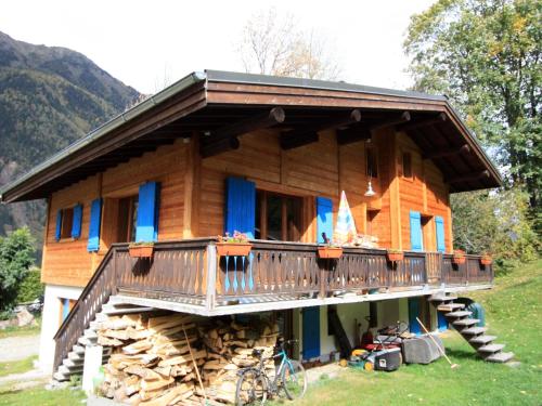 um chalé de madeira com uma varanda em cima de uma pilha de madeira em B&B Chalet Les Frenes em Chamonix-Mont-Blanc