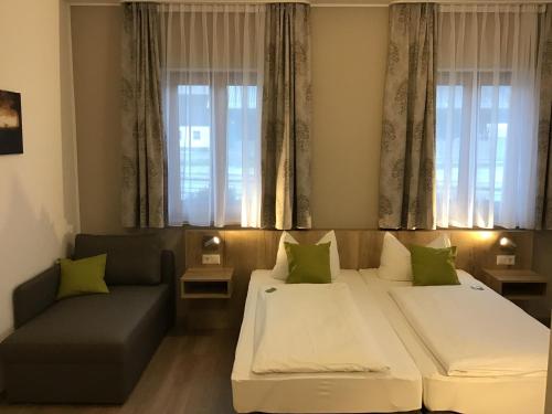 ein Wohnzimmer mit 2 Betten und einem Sofa in der Unterkunft Gasthof Hotel Esterer in Rosenheim