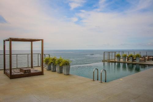 
a beach with a pool and a balcony overlooking the ocean at Prime Wave Residence in Mount Lavinia
