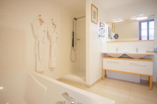 a white bathroom with a sink and a tub and a shower at Hotel Spa - Au Charme Rabelaisien in Amboise