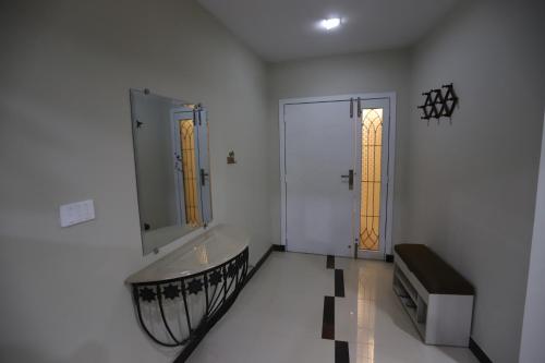 a white bathroom with a sink and a mirror at Aloche Apartments in Murree