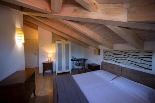sypialnia z dużym łóżkiem na poddaszu w obiekcie Villa Bellaria w mieście Riva del Garda