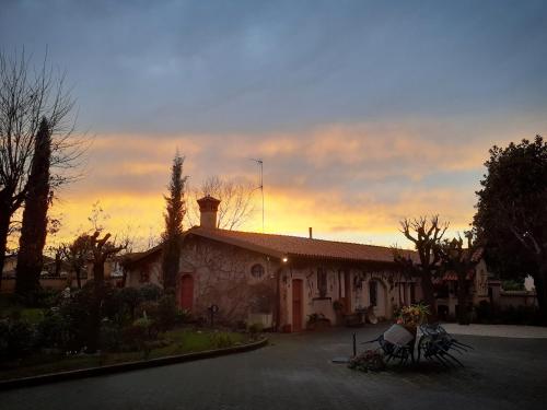 a building with a sunset in the background at Cascina CORTEPRIMAVERA, B&B del Baliot in Passirano