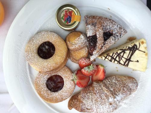 a plate of pastries and desserts on a table at Hotel Valacia in Pozza di Fassa