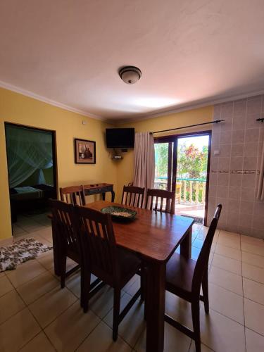 a dining room with a wooden table and chairs at Tri M Waves Lodge in Ponta do Ouro