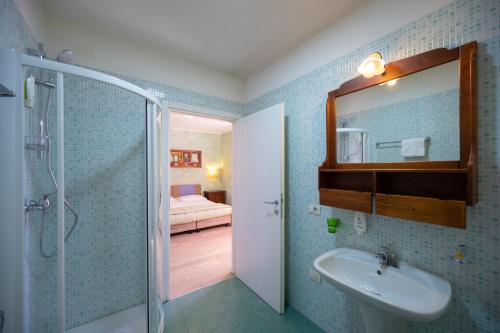 a bathroom with a shower and a sink and a mirror at Villa Bellaria in Riva del Garda