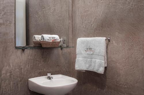 a bathroom with a sink and a mirror and towels at Hostal Oro Negro in Talara