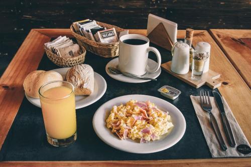 a table with plates of food and a glass of orange juice at Hotel Oro Negro in Talara