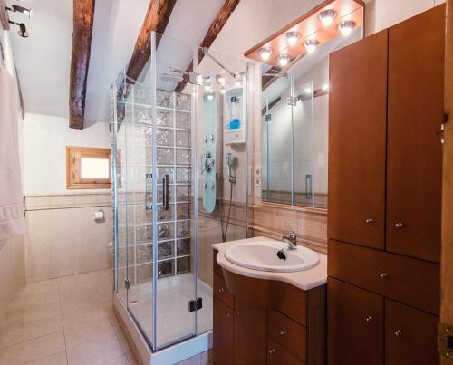 a bathroom with a sink and a glass shower at Casa rural la Posada Terra Alta Matarraña in Caseras