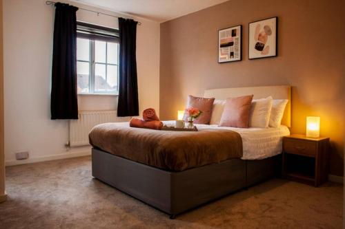 a bedroom with a bed with a nightstand and a window at 3 Bed Townhouse Stafford in Stafford