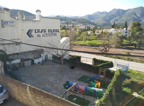 a playground in front of a building with a sign at La Casa del Carrebaix in Orba