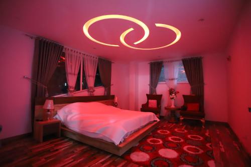 a pink bedroom with a bed and a chandelier at Aloche Apartments in Murree