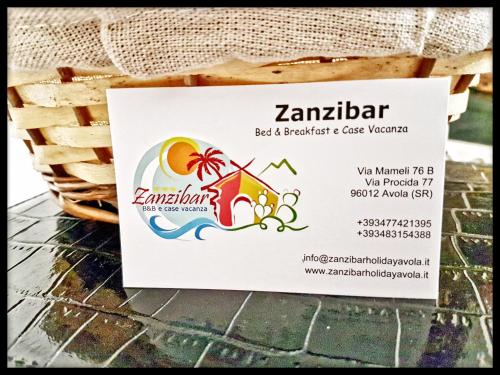 a basket with a ticket for a beach bar and a glass warmer at Zanzibar - Charming Rooms and Apartments in Avola