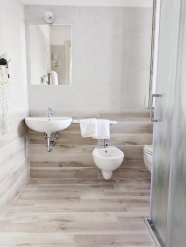 a bathroom with a sink and a toilet and a mirror at Holiday in Milano Marittima
