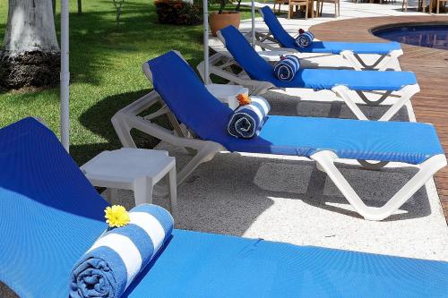 a group of blue and white chairs next to a pool at Holiday Inn Express Villahermosa by IHG in Villahermosa