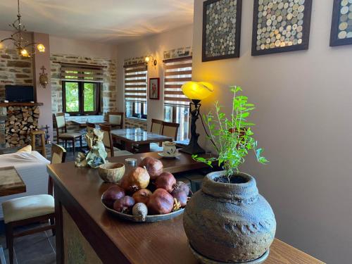 una sala de estar con una mesa con un bol de fruta en Hotel Maistra en Tsagarada