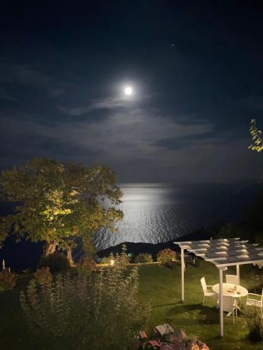 a view of the moon over the ocean at night at Hotel Maistra in Tsagarada