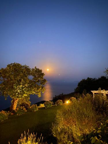 a view of the moon over the ocean at night at Hotel Maistra in Tsagarada