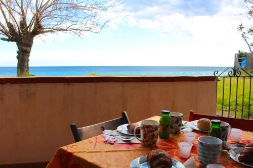 a table with food and a view of the ocean at House on the Sea in Mascali
