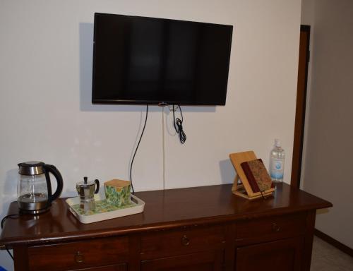 a flat screen tv on top of a wooden dresser at La Ninfea in Pisa