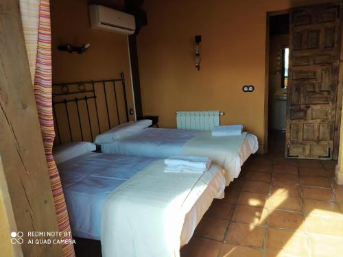 two beds sitting next to each other in a room at la felicidad de la tierra in Torija