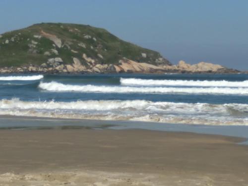 a beach with a mountain in the background at Studio Imbé in Imbituba