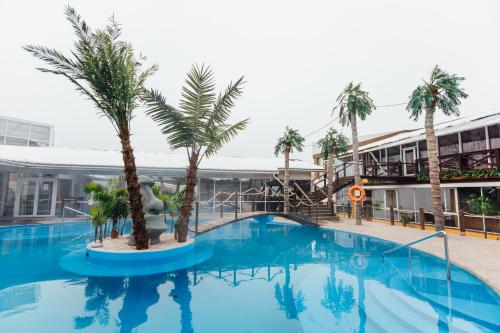 una gran piscina con palmeras frente a un edificio en Dolphin Planet Hotel & SPA, en Yaroslavl
