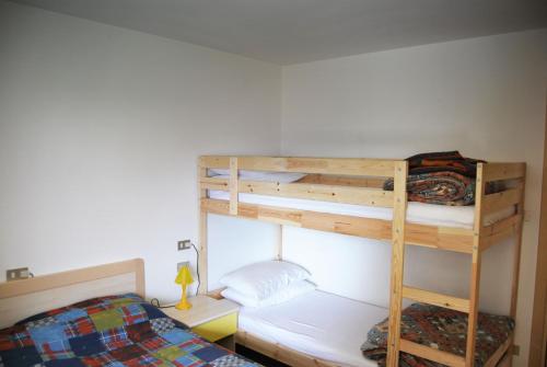 1 dormitorio con 2 literas y 1 cama en Appartamento Col Val di Fassa con giardino BAGNI RINNOVATI 2023, en Campitello di Fassa