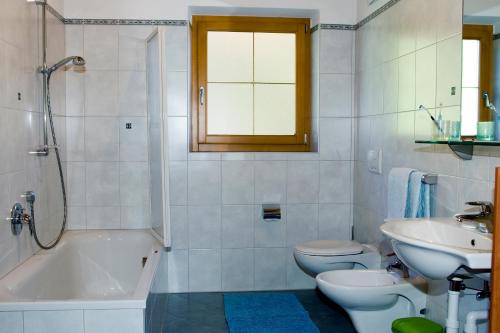 a bathroom with a sink and a tub and a toilet at Ferienwohnungen Zeppenhof in Santa Valpurga