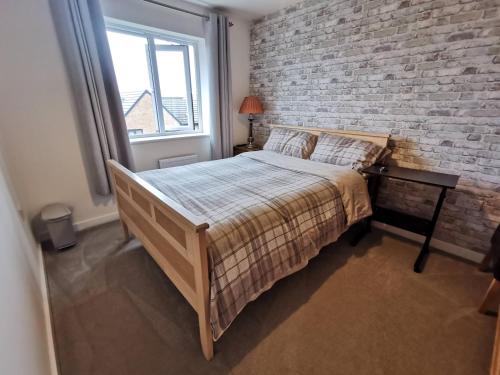 a bedroom with a bed and a brick wall at Helena's Place (7 minutes walk to Nottingham Train station) in Nottingham
