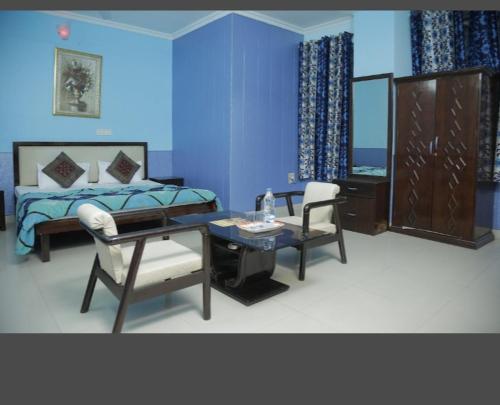 a bedroom with a bed and a table and a chair at HOTEL SITI CASTLE in Jalandhar