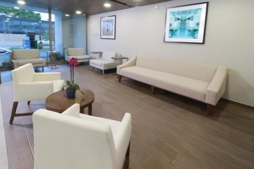 a waiting room with white couches and a table at Holiday Inn Express & Suites - Playa del Carmen by IHG in Playa del Carmen