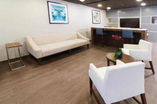 a living room with a couch and a table and chairs at Holiday Inn Express & Suites - Playa del Carmen by IHG in Playa del Carmen