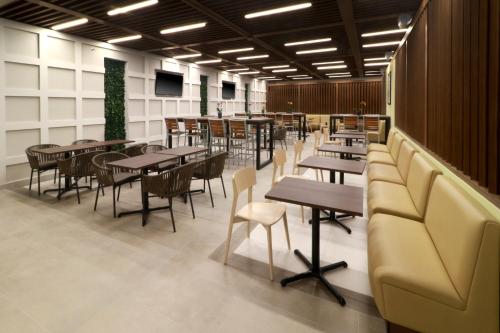 a restaurant with tables and chairs and a couch at Holiday Inn Express & Suites - Playa del Carmen by IHG in Playa del Carmen