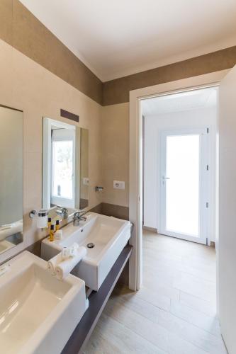 a bathroom with two sinks and a large mirror at Torre Cintola Greenblu Sea Emotions in Monopoli