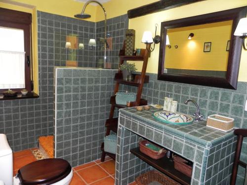 y baño con lavabo, aseo y espejo. en Casa Rural " LA PARRA", en Peralejos de las Truchas