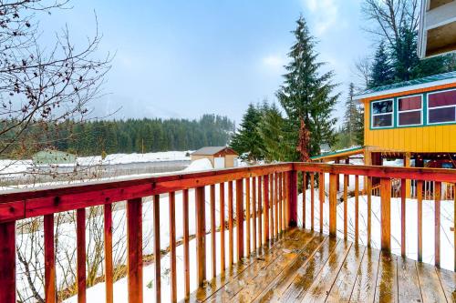 a house with a wooden deck in the snow at Breathtaking Hyak Home in Snoqualmie Pass