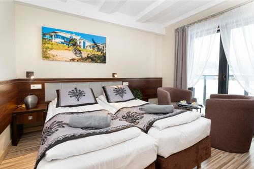 1 dormitorio con 1 cama grande con sábanas blancas en Słoneczny Stok, en Międzybrodzie Żywieckie