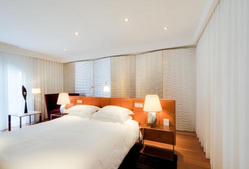 a bedroom with a large white bed and two lamps at Maison Pic in Valence