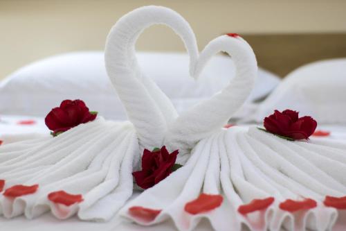 two white swans with red roses on a cake at Hotel Dan Inn Sorocaba by Nacional Inn in Sorocaba