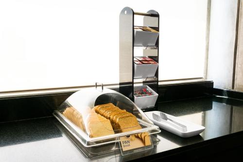 a counter with a tray of bread and cheese at Holiday Inn Express Toluca Galerias Metepec by IHG in Toluca