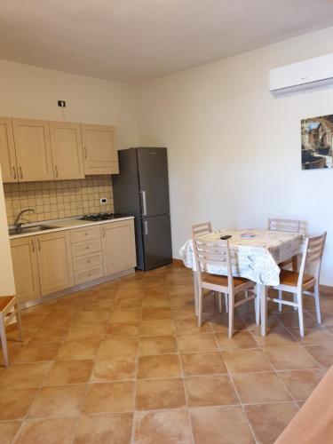 a kitchen with a table and chairs and a refrigerator at Green Park Residence in Foce Varano