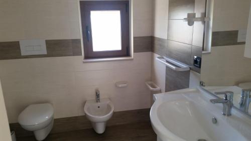 a bathroom with a sink and a toilet and a sink at Green Park Residence in Foce Varano
