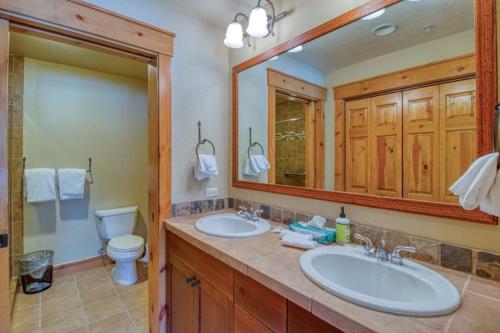 a bathroom with two sinks and a toilet and a mirror at Private Family Friendly 2 Bedroom Townhome Located In East Keystone With Access To Free Shuttle Service in Keystone