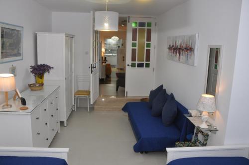 un soggiorno con divano blu e un corridoio di Private Apartment in Pembroke St Julians a Pembroke