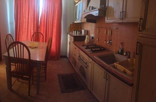 a kitchen with a table and a sink and a stove at IL bejta in Qrendi