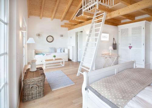 Un dormitorio con una escalera y una cama en una habitación en Belle Maison - Das kleine Hotel en Werbach